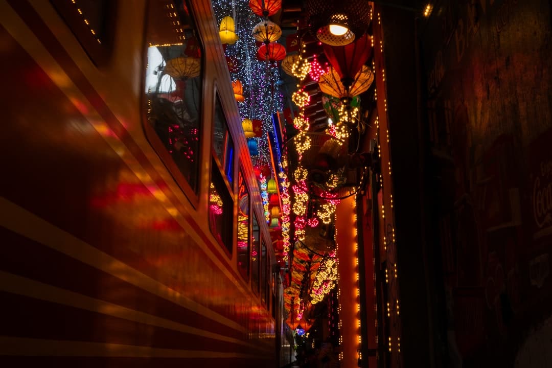 Colorful lanterns and lights illuminate a narrow passage.