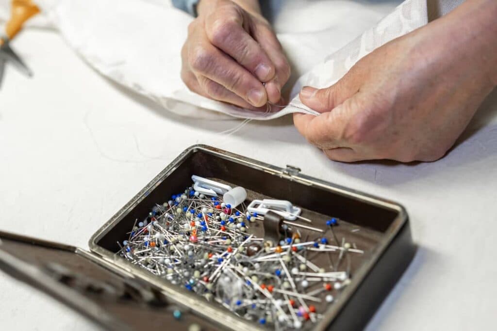 Mains de Sylvie cousant un abat-jour avec ses épingles