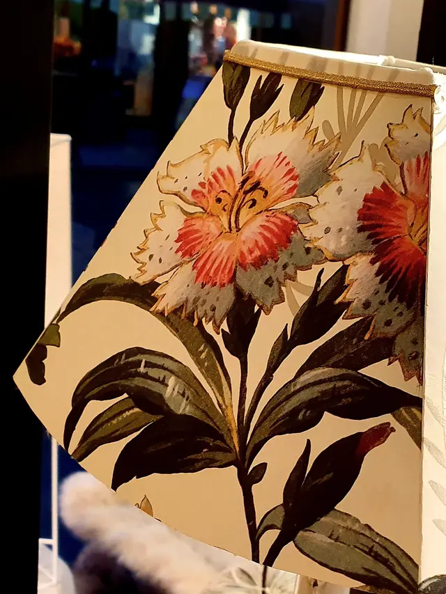 Abat-jour lanterne en tissu fleurs anciennes, allumé sur un pied sculpté dans la boutique Illumine à Cormeilles