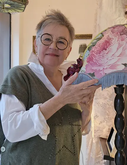 Sylvie Lemarchand, Maître Artisan d’Art, présentant un abat-jour fleuri à franges dans son atelier de Cormeilles